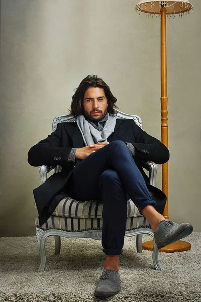 Az igazi klasszikusok mindig divatosak. Portré egy stílusosan öltözött férfiról, aki egy széken ül a stúdióban.. — Stock Fotó