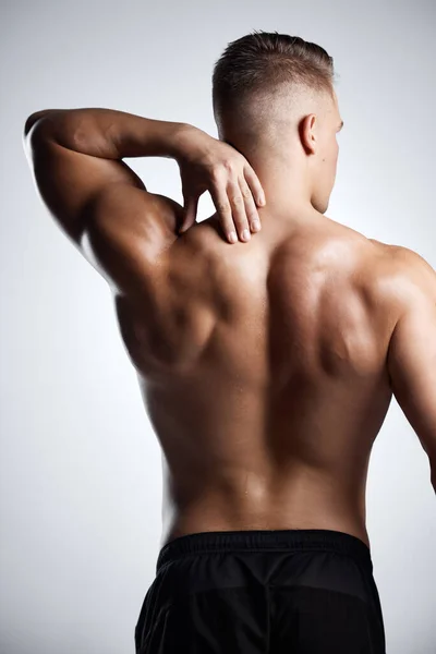 Du skulle se hans gym selfies. Studio skott av en muskulös ung man poserar mot en grå bakgrund. — Stockfoto