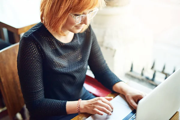 İnternetin ücretsiz olduğu her yere giderim. Bir kafede dizüstü bilgisayarını kullanan genç bir kadının görüntüsü.. — Stok fotoğraf