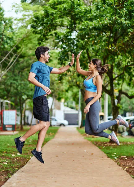 Ese entrenamiento valió la pena. Tiro de una joven pareja deportiva chocando los cinco en el aire mientras hace ejercicio al aire libre. — Foto de Stock
