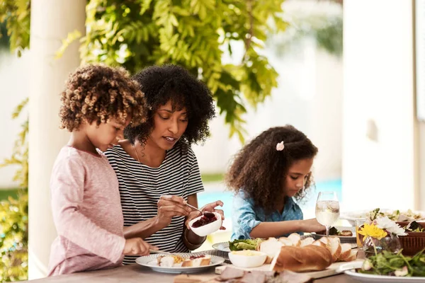 让我们吃孩子。拍下了一个年轻女子和孩子在家里吃饭的镜头. — 图库照片