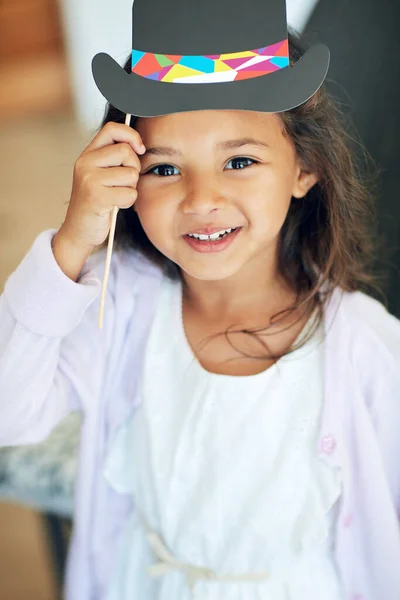 Тебе нравится моя модная шляпа. Портрет милой маленькой девочки, позирующей с реквизитом дома. — стоковое фото