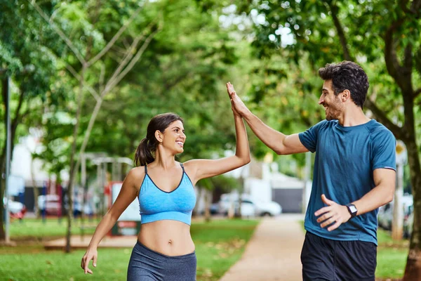 Αυτό ακριβώς χρειαζόμασταν για να κάνουμε τις καρδιές μας να τρέξουν. Shot of a sporty young couple κόλλα πέντε κατά την άσκηση σε εξωτερικούς χώρους. — Φωτογραφία Αρχείου