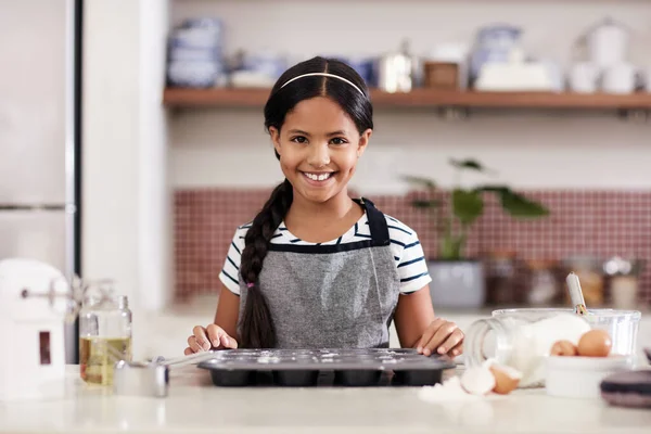 Ze heeft alles wat ze nodig heeft, ze is klaar om te bakken. Gehakt schot van een schattig klein meisje bakken in de keuken thuis. — Stockfoto