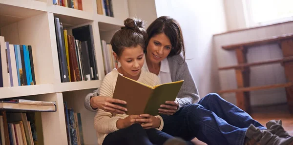 Le paradis des amoureux du livre. Une mère et sa fille lisant un livre ensemble à la maison. — Photo