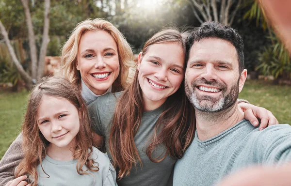 Ele é um grande marido e um pai incrível. Tiro de um casal e suas duas filhas posando juntos fora. — Fotografia de Stock