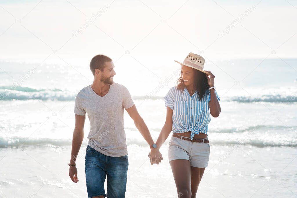 Im so happy to have you in my life. Shot of a young couple walking along the beach.