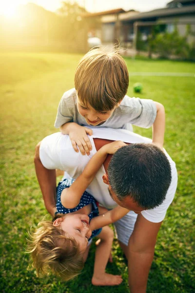 Estos son los momentos que se aprecian para siempre. Shot de un padre jugando con su adorable hijo y su hija fuera. — Foto de Stock