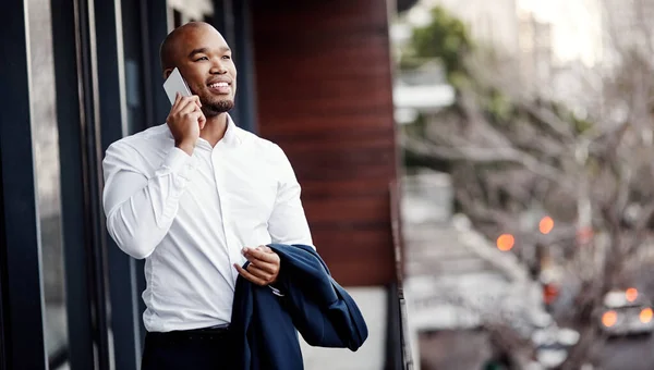 Ele responde ansiosamente sempre que a oportunidade chama. Tiro de um belo jovem empresário falando em um celular fora de seu escritório. — Fotografia de Stock