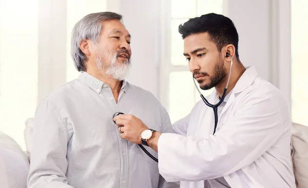 Déjame escucharte. Inyección de un médico escuchando los latidos del corazón de un hombre mayor durante un chequeo. —  Fotos de Stock