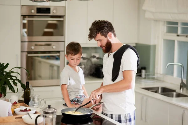 And thats the secret to fluffy scrambled eggs. Shot of an adorable little boy and his father making breakfast together at home.