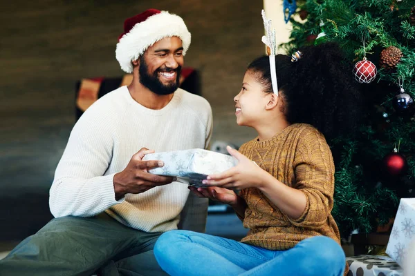 Találd ki, mit vett neked a Télapó! Egy aranyos kislányról készült, aki ajándékokat bontott fel az apjával karácsonykor otthon.. — Stock Fotó