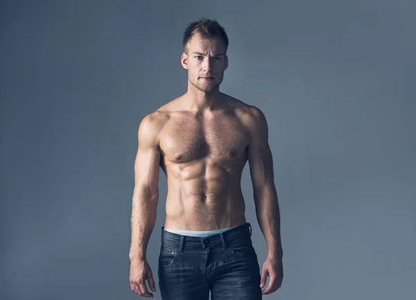 Brody und gut aussehend. Studioaufnahme eines hemdlosen, muskulösen Mannes in Jeans. — Stockfoto