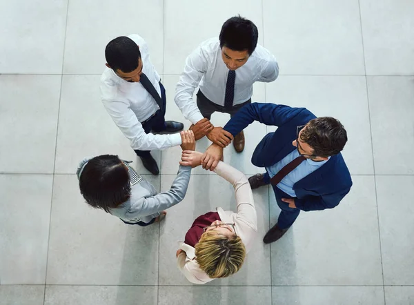Si nos unimos, podemos conquistar. Foto de alto ángulo de un grupo diverso de empresarios que unen sus manos en unidad. — Foto de Stock