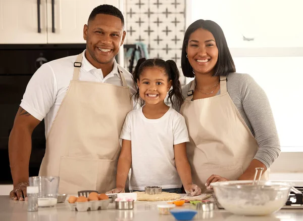 Welkom in onze gekke keuken. Portret van een schattig klein meisje bakken met haar ouders thuis. — Stockfoto
