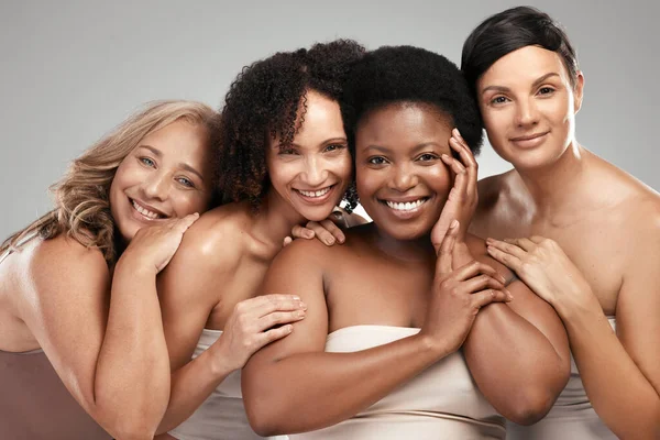 Nunca vais adivinhar a nossa idade. Tiro de um grupo diversificado de mulheres de pé e abraçando uns aos outros no estúdio. — Fotografia de Stock