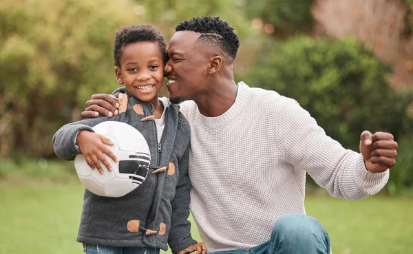 Zostanie zawodowcem. Portret chłopca i jego ojca bawiących się piłką nożną na świeżym powietrzu. — Zdjęcie stockowe
