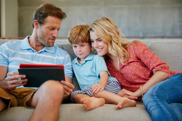 Zawsze jest coś rozrywkowego do oglądania online. Zdjęcie rodziny korzystającej z tabletu cyfrowego w domu. — Zdjęcie stockowe