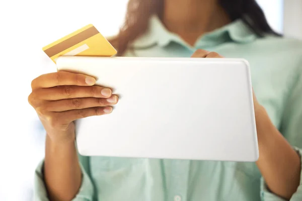 J'ai besoin de faire des paiements rapides. Plan recadré d'une personne méconnaissable utilisant une carte de crédit et une tablette numérique pour faire des achats en ligne à la maison. — Photo