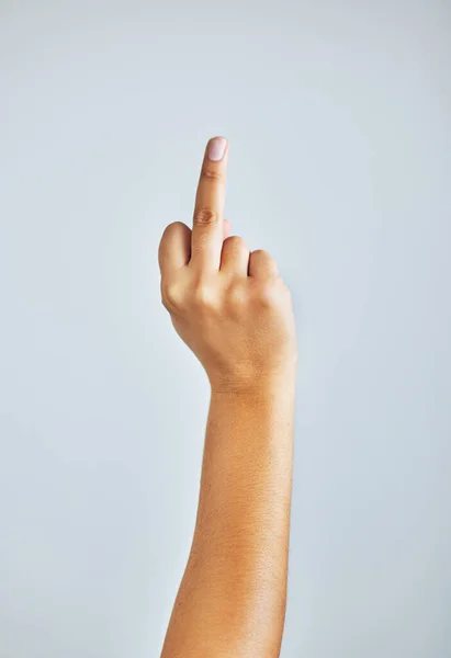 Це моя думка. Студійний знімок невпізнаваної жінки, що показує її середній палець на сірому фоні . — стокове фото