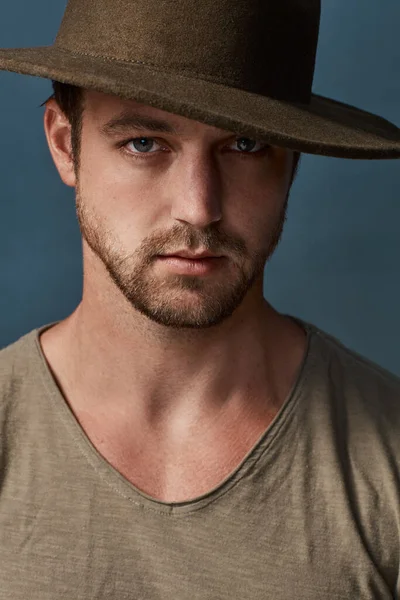 Καπέλα είναι ένα μεγάλο αξεσουάρ για να ανυψώσει το στυλ σας. Studio πορτρέτο ενός όμορφου νεαρού άνδρα φορώντας ένα καπέλο σε σκούρο φόντο. — Φωτογραφία Αρχείου