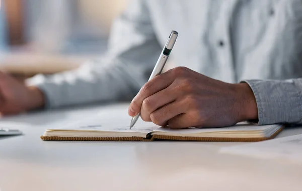 La planificación y la productividad van de la mano. Fotografía de un hombre de negocios irreconocible escribiendo en un cuaderno durante una noche en el trabajo. — Foto de Stock