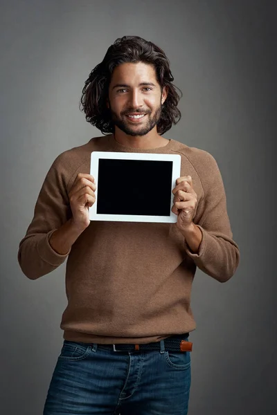 Fico feliz em dar o meu apoio a isto. Estúdio de um jovem bonito segurando um tablet digital com uma tela em branco contra um fundo cinza. — Fotografia de Stock
