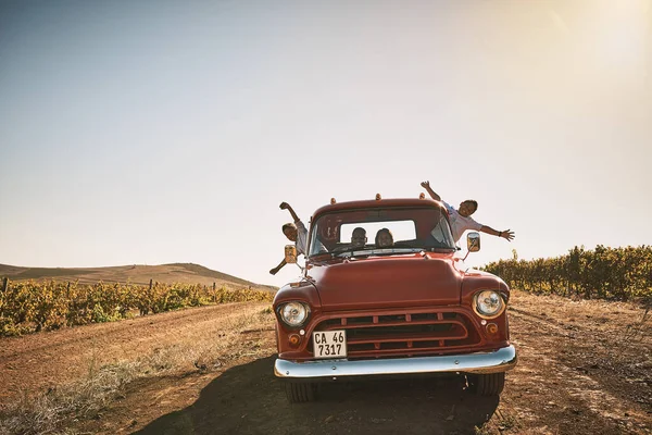 Να αράζουμε και να περνάμε καλά. Πυροβολισμός μιας χαρούμενης νεαρής οικογένειας που οδηγούσε με ένα κόκκινο φορτηγάκι σε έναν αγροτικό δρόμο έξω. — Φωτογραφία Αρχείου