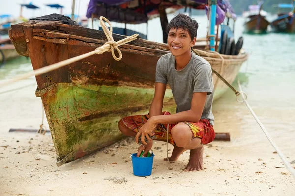 Mijn boot is mijn levensonderhoud. Portret van een man uit Thailand naast zijn boot aan de waterkant. — Stockfoto