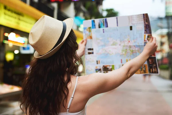 En una misión para ver tantas atracciones como sea posible. Fotografía recortada de una joven usando un mapa mientras viajaba por una ciudad extranjera. — Foto de Stock