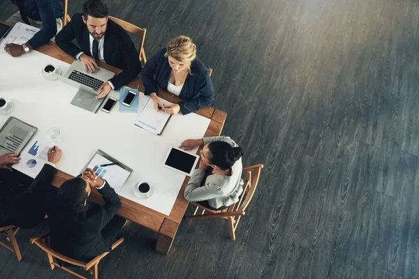 Het business team om te verslaan. Hoge hoek foto van een team van zakenmensen werken rond een tafel in het kantoor. — Stockfoto