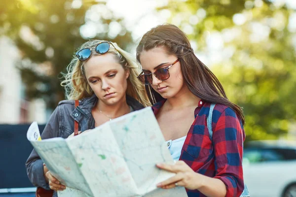 Próbujemy znaleźć drogę. Przycięte ujęcie dwóch pięknych przyjaciółek patrzących na mapę kierunków w mieście. — Zdjęcie stockowe