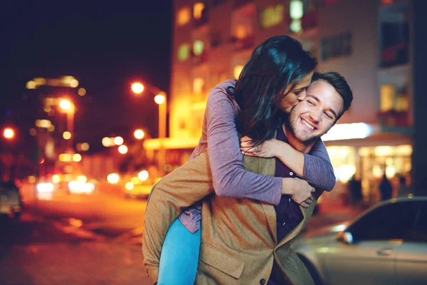 I had the best time ever. Cropped shot of a handsome young man piggybacking his girlfriend while out on a date in the city. — Stock Photo, Image