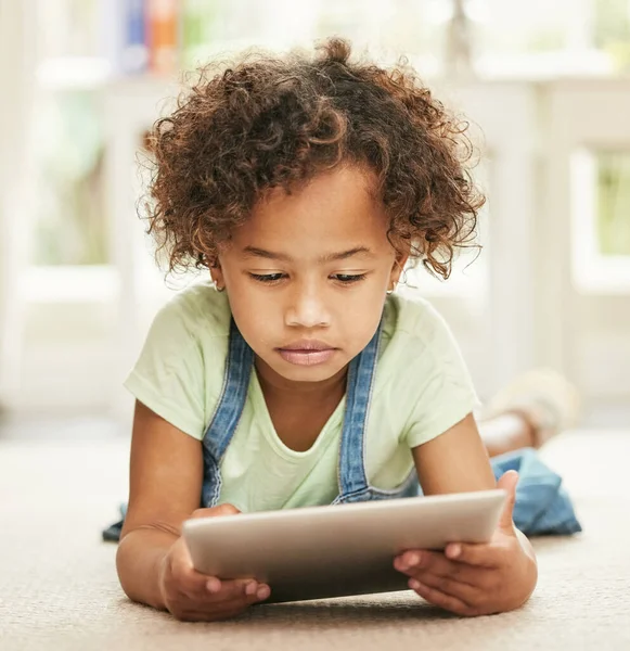 La chiamano ora delle tavolette. Girato di una bambina che usa un tablet digitale a casa. — Foto Stock