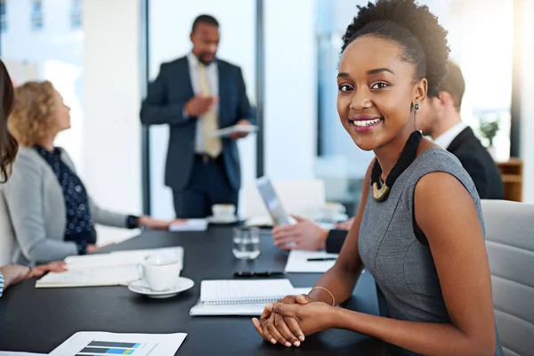 Estas presentaciones son siempre informativas. Retrato de una joven empresaria que trabaja en la sala de juntas con sus colegas de fondo. — Foto de Stock