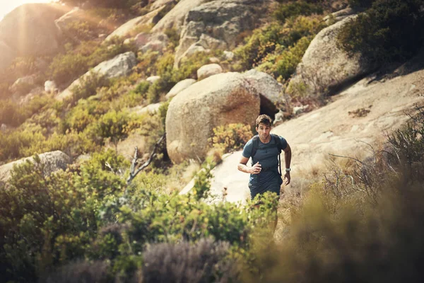 A hegyi ösvény megfékezése. Vágott felvétel egy jóképű fiatalemberről, aki a hegyi túráján futott.. — Stock Fotó