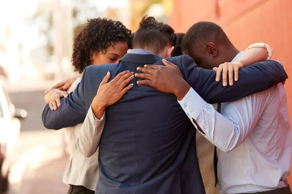 Noi traiamo sostegno e motivazione l'uno dall'altro. Girato di un gruppo di uomini d'affari in piedi insieme in un abbraccio all'aperto. — Foto Stock