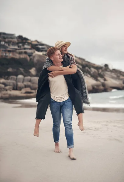 Kumsalı neredeyse seni sevdiğim kadar çok seviyorum. Sahilde yürürken kız arkadaşını sırtında taşıyan bir adamın fotoğrafı.. — Stok fotoğraf