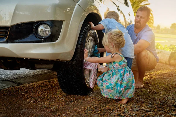 Вони завжди прагнуть допомогти татові помити машину. Постріл родини, що миє машину разом.. — стокове фото