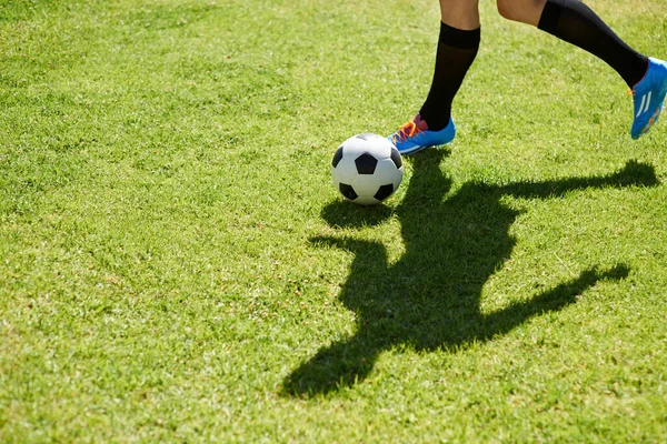 Мистецтво дриблінгу. Постріл молодого футболіста, який дриблінг м'яча на полі . — стокове фото