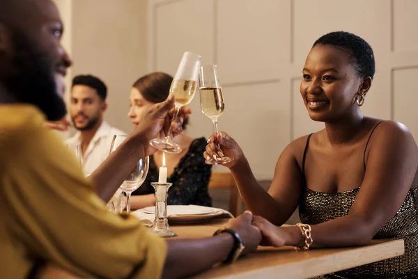 Ma vie ne serait pas la même sans toi. Tourné d'un jeune couple heureux assis avec des amis et grillé au champagne lors d'un dîner du Nouvel An. — Photo