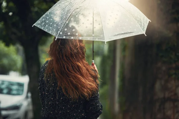 Нехай дощ змиє всі турботи вчора. Знімок заднього виду невпізнаваної жінки, що йде під дощем надворі . — стокове фото