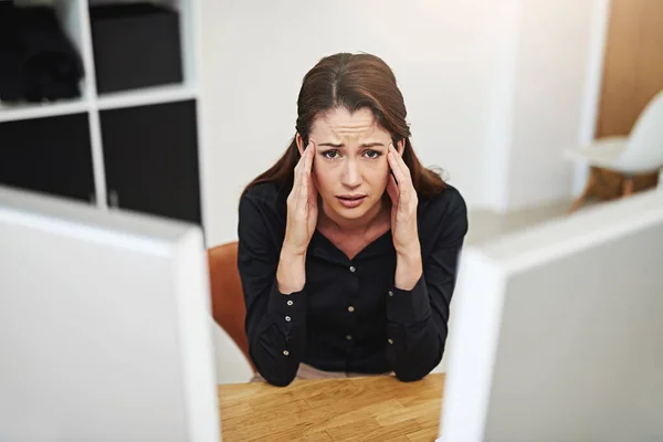 Ik wil hier niet zijn. Portret van een jonge zakenvrouw die gestresst naar haar bureau kijkt. — Stockfoto