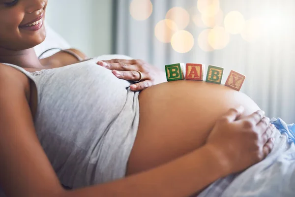 Estou tão pronta para ser mãe. Tiro cortado de uma mulher grávida com blocos de madeira na barriga que soletram a palavra bebê. — Fotografia de Stock