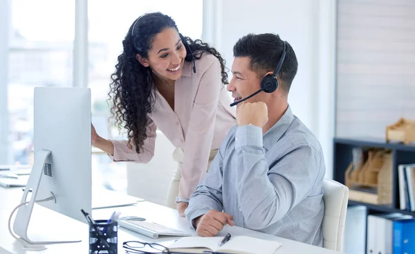 You did it. Shot of two young call centre agents using a computer in the office during the day. — Stock Photo, Image