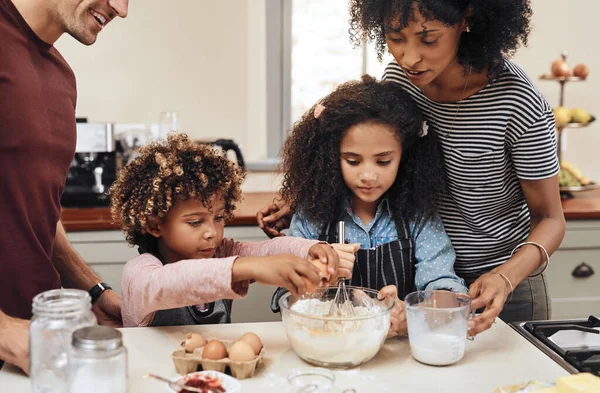 Wat het heerlijk maakt, is de liefde die je erin stopt. Gehakt schot van een jong paar bakken thuis met hun twee kinderen. — Stockfoto