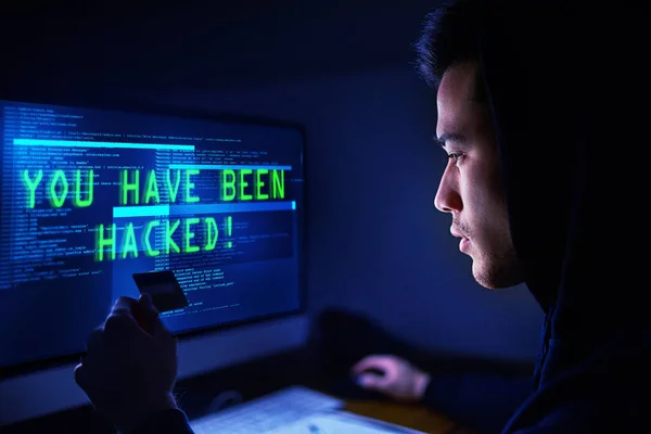 Most már az enyém a pénzed. Egy kapucnis hackerről, aki számítógépet használ a sötétben.. — Stock Fotó