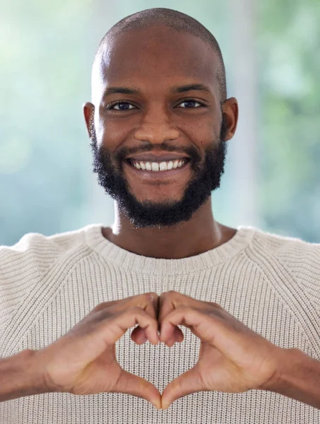 I heart you. Shot of a young man making a heart shape with his hands.