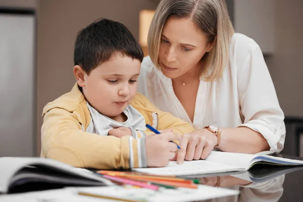 Eres un chico muy listo. Foto de una hermosa madre ayudando a su hijo con su tarea. —  Fotos de Stock