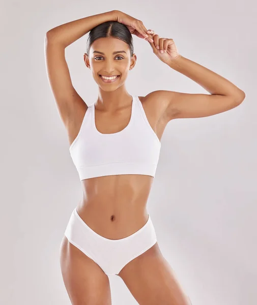 Estou em grande forma, não por acaso, mas pelo esforço. Tiro de uma jovem mulher em forma posando em sua roupa interior contra um fundo de estúdio. — Fotografia de Stock